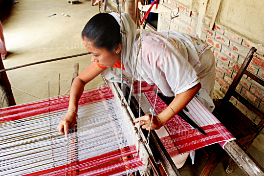 An Assamese woman weaving “Gamocha”