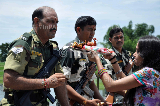 Indian girl tying Rakhi to BSF Jawans